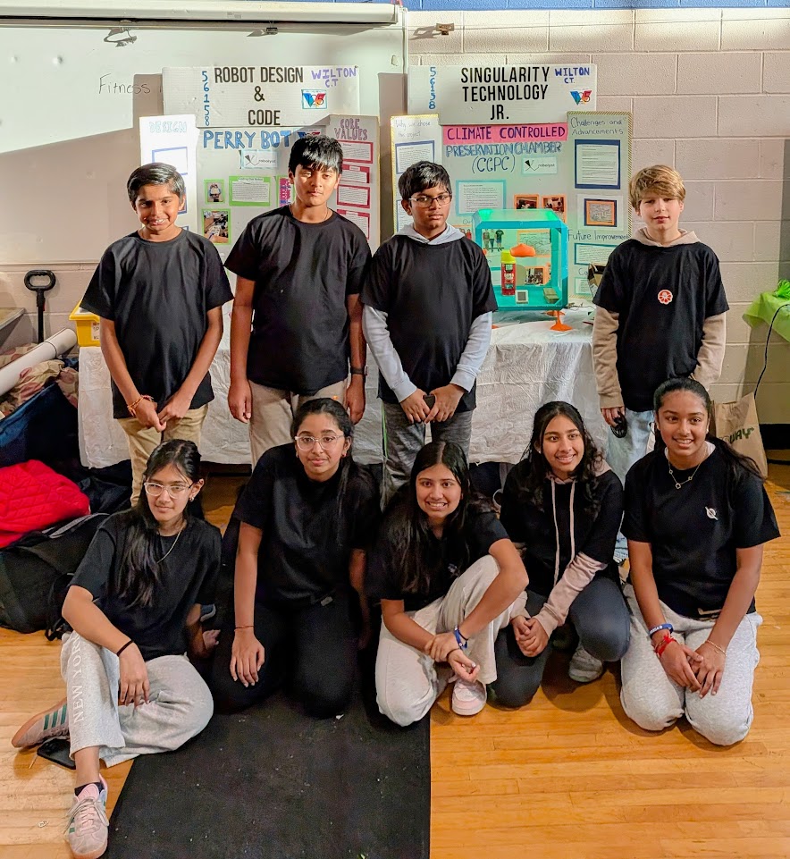 A middle-school team posing in front of their Robot Design and Innovation Project boards